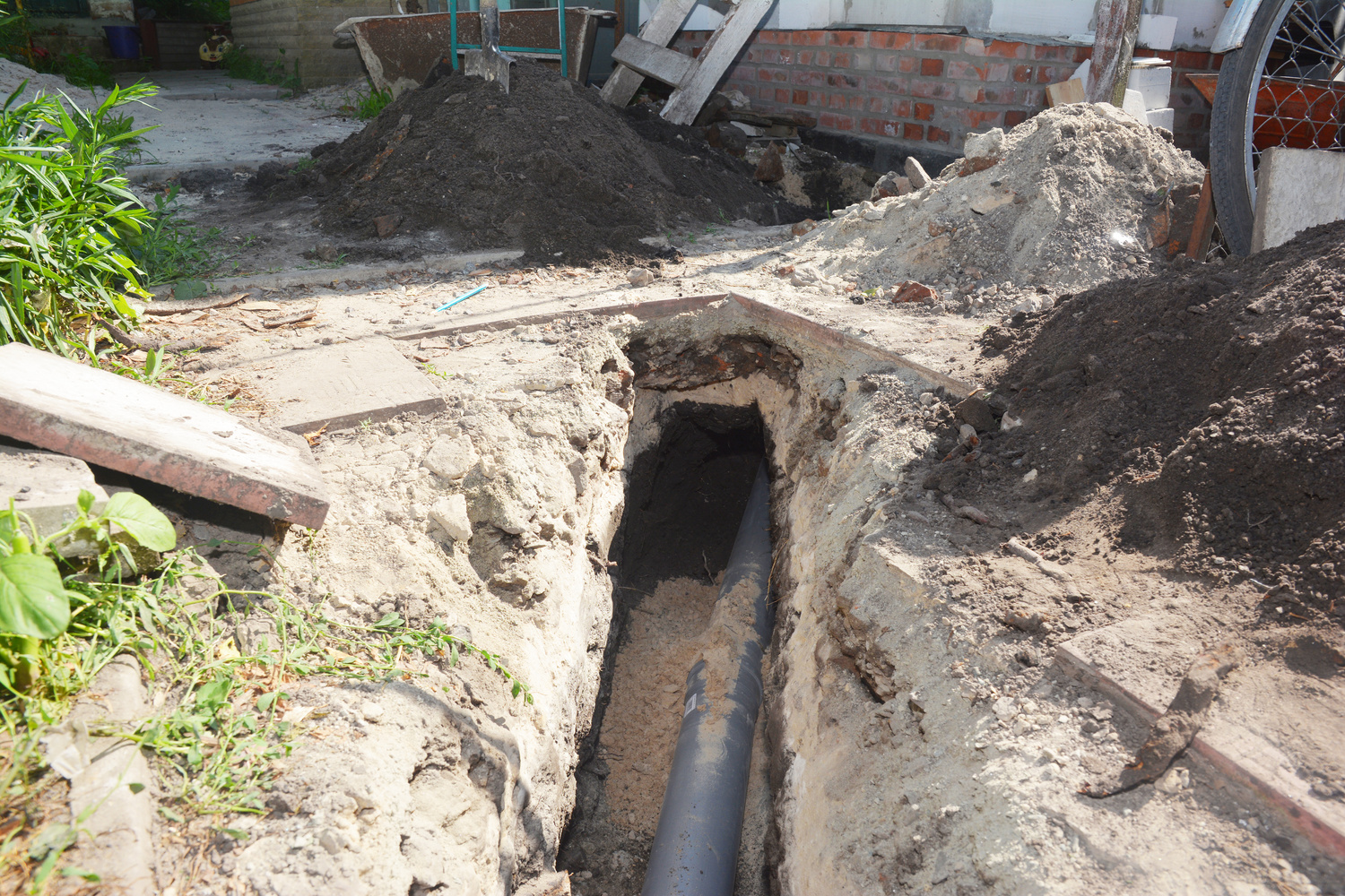 Digging a trench for the main drain pipe, sewer line to a sewer or septic tank. Sewer line replacement or repair.